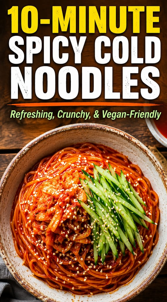 A bowl of spicy Korean cold noodles (Bibim-guksu) coated in red gochujang sauce, topped with chopped kimchi, fresh julienned cucumber, and sesame seeds.